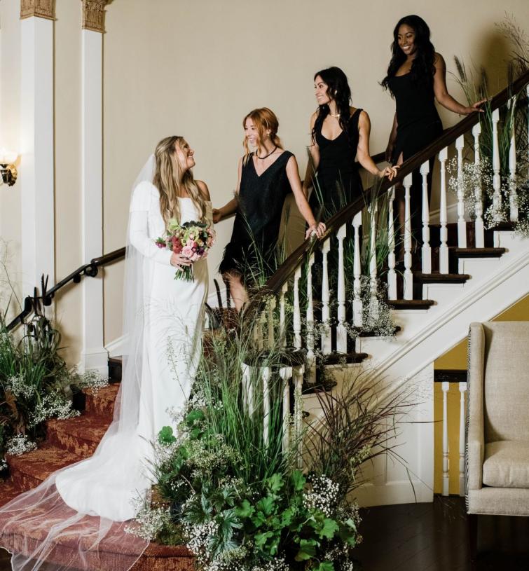 Bride and bridesmaids standing on stairs smiling